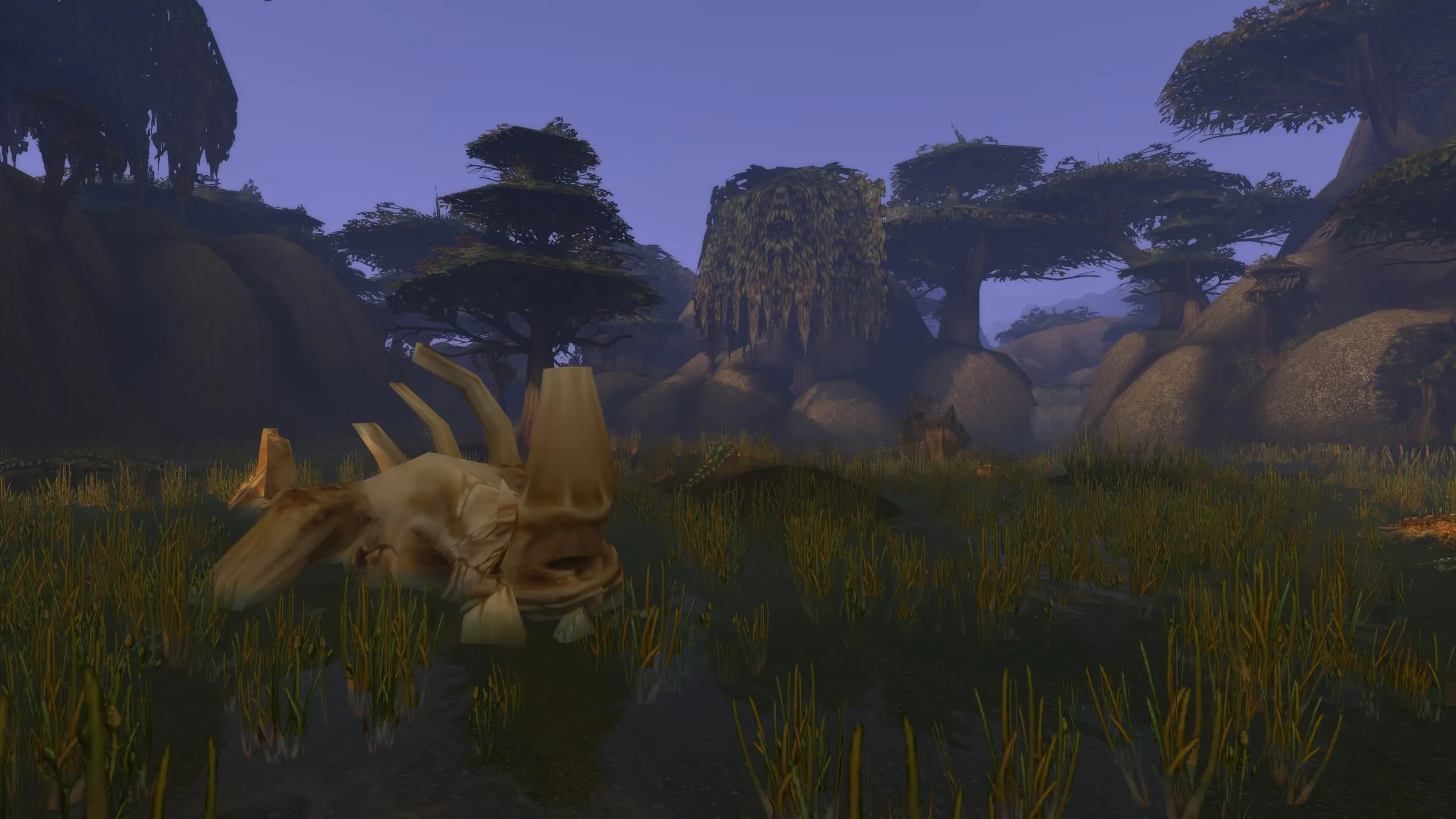 A huge fossilised skull half-buried in grass beneath spreading trees